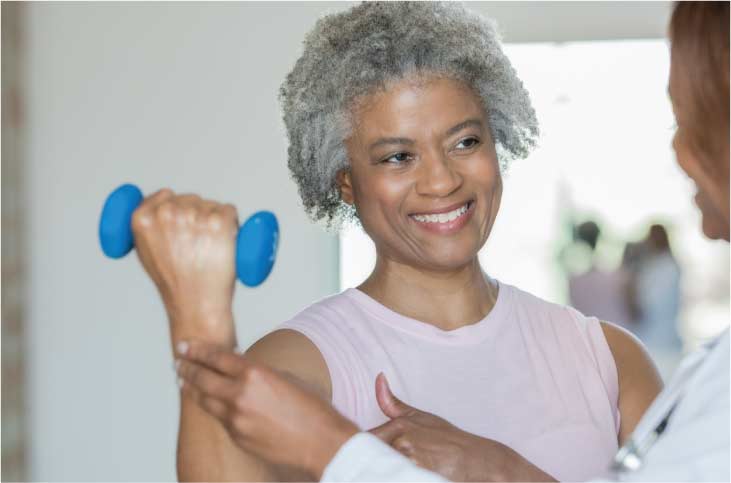 black women lifting dumbell with doctor health care